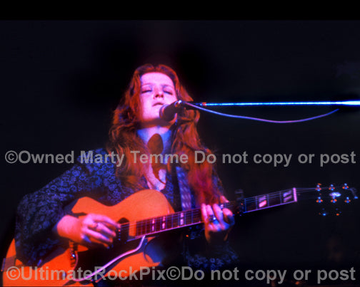 Photo of Bonnie Raitt playing a Gibson guitar in 1974 by Marty Temme