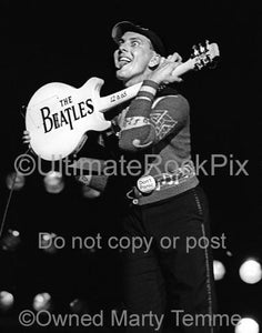 Photo of Rick Nielsen of Cheap Trick holding up his guitar with the words "The Beatles" on the back of it in 1979 by Marty Temme