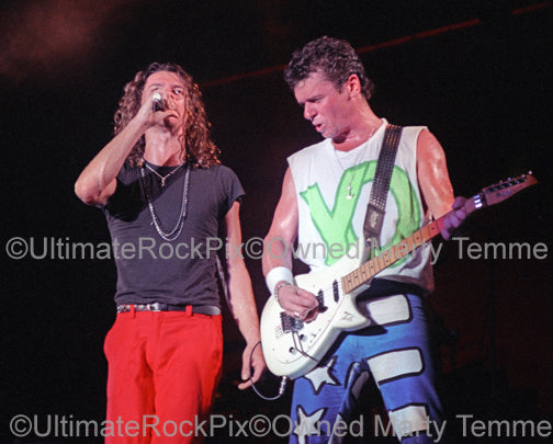 Photo of Michael Hutchence and Tim Farriss of INXS in concert in 1988 by Marty Temme