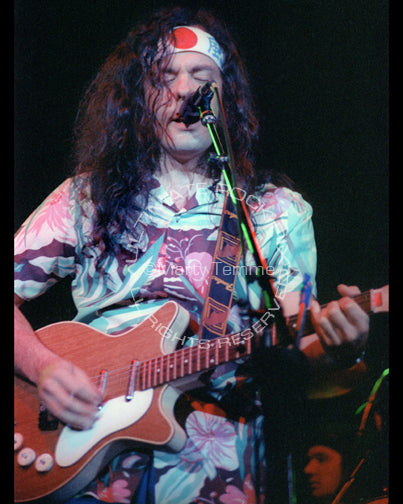 Photo of musician David Lindley playing a Danelectro guitar in concert in 1981 by Marty Temme