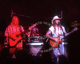 Photo of Gregg Allman and Dickey Betts playing guitar together in concert in 1994 - allmansgd9415