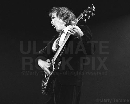 Photo of Angus Young of AC/DC playing a Gibson SG by Marty Temme