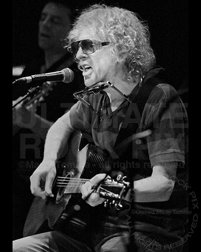 Black and white photo of Ian Hunter playing acoustic guitar in 2007 by Marty Temme