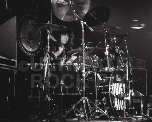 Photo of Frankie Banali of Quiet Riot in concert in 1983 by Marty Temme