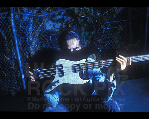 Photo of Robert DeLeo of Stone Temple Pilots holding his bass guitar during a photo shoot by Marty Temme