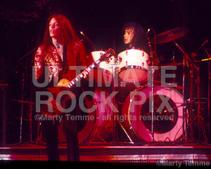 Photo of Scott Gorham and Brian Downey of Thin Lizzy in concert in 1977 by Marty Temme