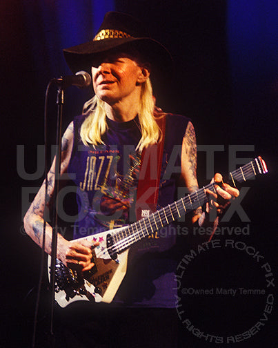 Photo of Johnny Winter playing his Lazer guitar in concert in 1998 by Marty Temme