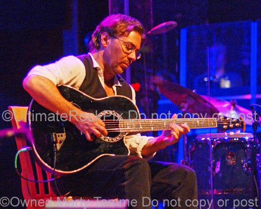 Photo of Al Di Meola playing acoustic guitar in concert in 2006 by Marty Temme