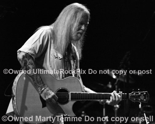 Photo of Gregg Allman of The Allman Brothers playing acoustic guitar in concert by Marty Temme