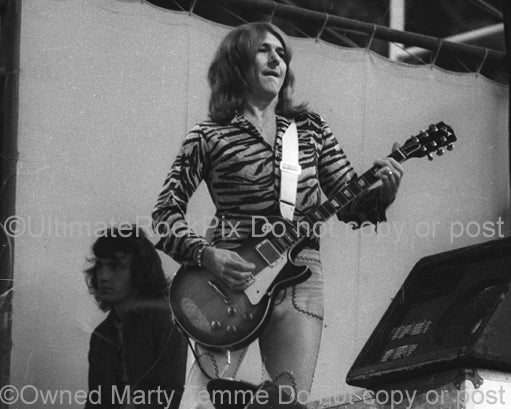 Black and white photo of Mick Ralphs of Bad Company playing a Gibson Les Paul onstage in 1974 by Marty Temme