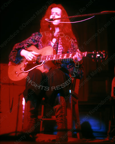 Photo of Bonnie Raitt playing a hollowbody Gibson guitar in 1974 by Marty Temme