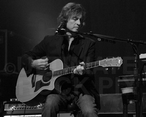 Black and white photo of Brett Tuggle of Fleetwood Mac playing acoustic guitar in concert by Marty Temme