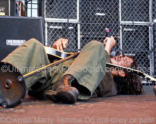 Photo of Chris Cornell of Soundgarden singing while lying down onstage in 1992 by Marty Temme