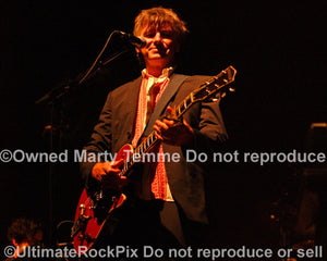 Photo of Neil Finn of Crowded House playing a Gretsch guitar in concert by Marty Temme