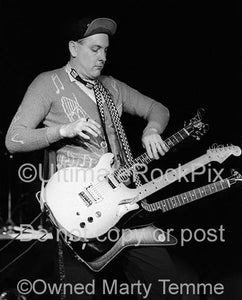 Photo of Rick Nielsen of Cheap Trick playing three guitars in concert in 1979 by Marty Temme