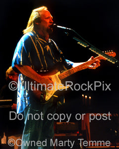 Photo of Stephen Stills of CSNY playing a Stratocaster in concert by Marty Temme