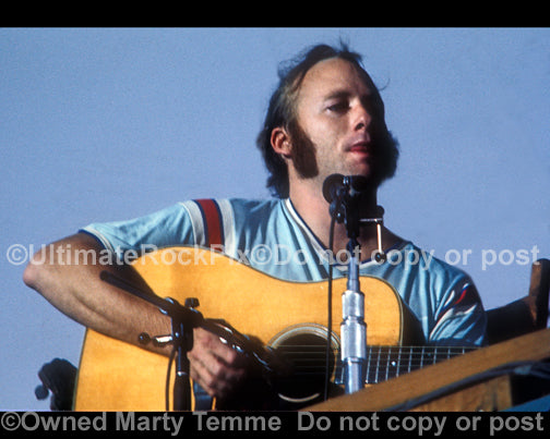 Photo of Stephen Stills of CSNY playing acoustic guitar in concert in 1974 by Marty Temme