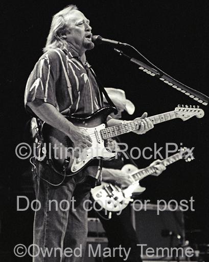 Black and white photo of Stephen Stills of CSNY playing a Stratocaster in concert by Marty Temme