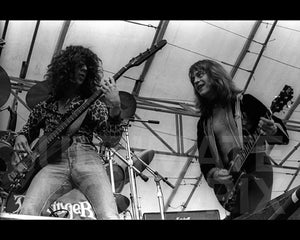 Photo of Rick Derringer and Kenny Aaronson of Derringer in concert in 1977 by Marty Temme