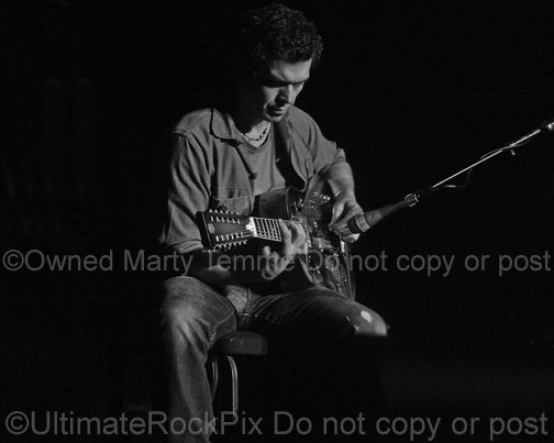 Black and white photo of Doyle Bramhall II playing a 12 string resonator guitar in 2010 by Marty Temme