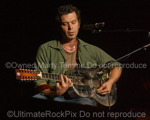 Photo of Doyle Bramhall II playing a 12 string resonator guitar in concert in 2010 by Marty Temme
