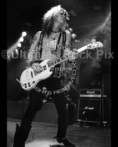 Black and white photo of Duff McKagan of Guns N' Roses playing a Gibson SG in concert in 1991 by Marty Temme