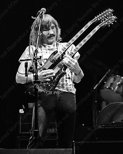Black and white photo of Joe Walsh of The Eagles playing a doubleneck SG in concert in 1980 by Marty Temme