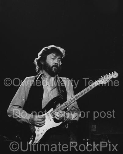 Black and white photo of Eric Clapton playing his black Stratocaster in 1979 by Marty Temme
