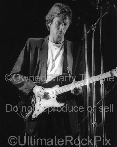 Photo of Eric Clapton playing his black Stratocaster with Roger Waters in concert 1984 by Marty Temme