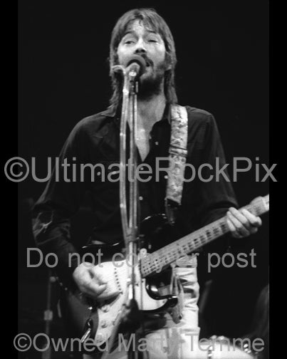 Black and white photo of Eric Clapton playing his Stratocaster in 1974 -  ecbw743