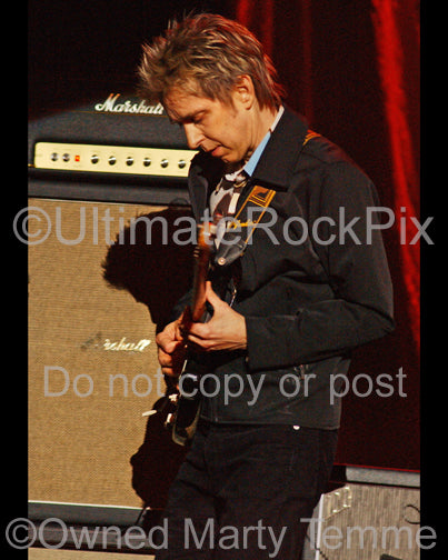 Photo of Eric Johnson standing in front of his Marshall stack in concert by Marty Temme