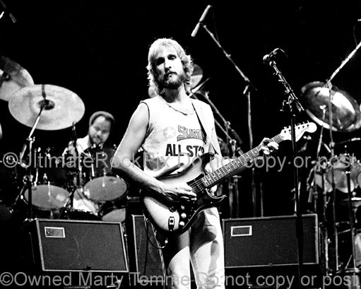 Photo of Mike Rutherford of Genesis onstage in 1977 by Marty Temme