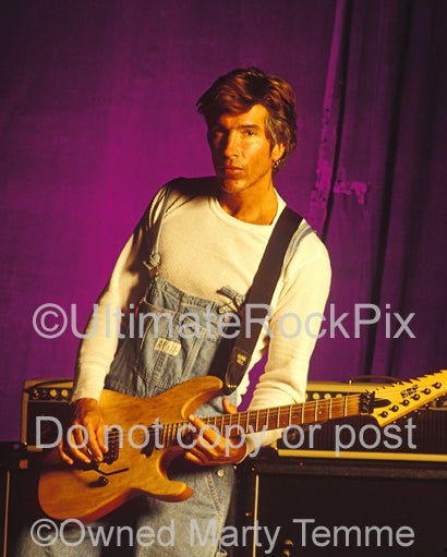 Photo of George Lynch holding a ESP guitar during a photo shoot in 1995 by Marty Temme