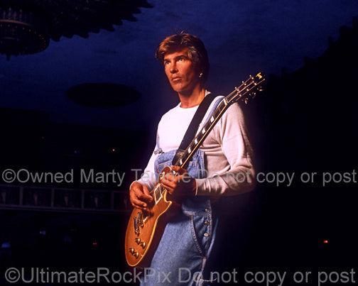 Photo of George Lynch holding a Les Paul during a photo shoot in 1995 by Marty Temme