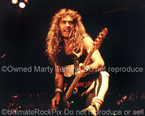 Photo of Steve Harris of Iron Maiden performing onstage in 1985 by Marty Temme