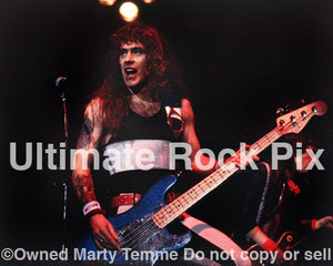 Photo of Steve Harris of Iron Maiden playing bass onstage in 1985 by Marty Temme