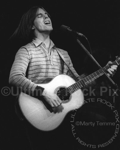 Photo of Jackson Browne playing acoustic guitar in concert in 1978 by Marty Temme