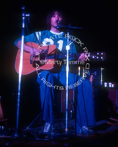 Photo of Jim Messina of Loggins and Messina playing acoustic guitar in 1973 by Marty Temme