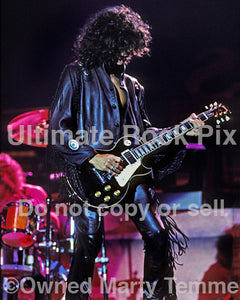 Photo of guitarist Joe Perry playing a black Gibson Les Paul Standard in 1990 by Marty Temme
