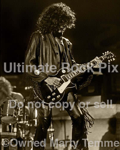 Black and white sepia tint photo of Joe Perry playing a Les Paul in 1990 by Marty Temme