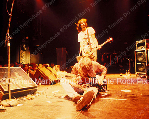 Photo of Kurt Cobain of Nirvana sitting on the stage in concert in 1991 in Hollywood, California by Marty Temme