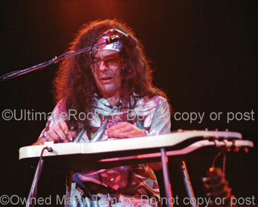 Photo of musician David Lindley playing lap steel guitar in concert by Marty Temme