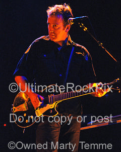 Photo of Jim Moginie of Midnight Oil playing a Gretsch guitar in concert in 2002 by Marty Temme