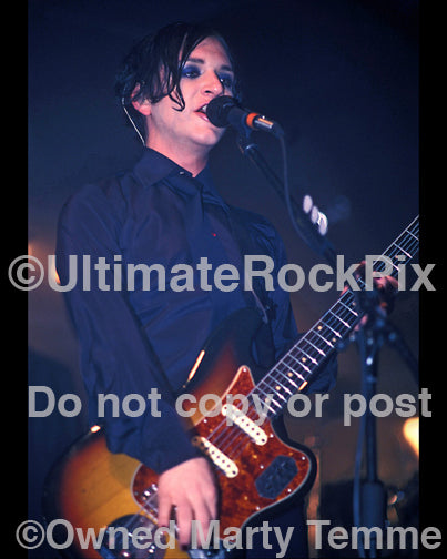 Photo of guitar player Brian Molko playing a Fender Jaguar in concert by Marty Temme