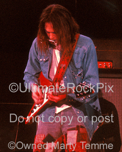 Photo of Neil Young playing a Gibson Flying V in concert in 1973 by Marty Temme