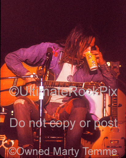 Photo of Neil Young playing his Martin in concert in 1973 by Marty Temme