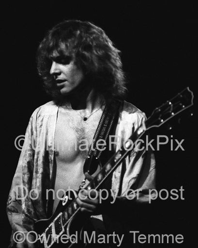 Black and white photo of Peter Frampton playing his Les Paul in concert in 1976