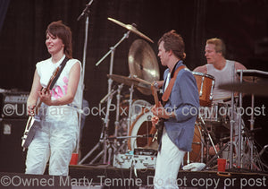 Photo of Chrissie Hynde, Robbie McIntosh and Martin Chambers of The Pretenders in concert in 1983 by Marty Temme