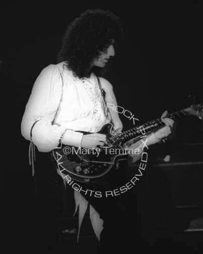 Photo of Brian May of Queen in concert in 1977 by Marty Temme