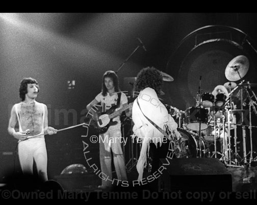 Photo of Freddie Mercury, Brian May, Roger Taylor and John Deacon of Queen in concert in 1977 by Marty Temme